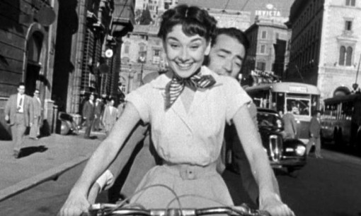 Audrey_Hepburn_and_Gregory_Peck_on_Vespa_in_Roman_Holiday_trailer.jpg